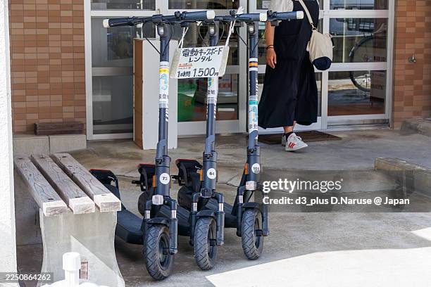 tourists riding electric skateboards.in recent years, the rental of easy motorized vehicles has developed on zamami island. - electric skateboard stock pictures, royalty-free photos & images