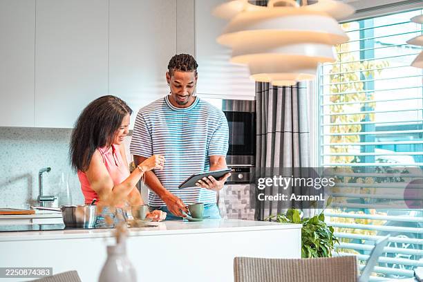 delighted couple using digital device for home budget review - convenience stock pictures, royalty-free photos & images