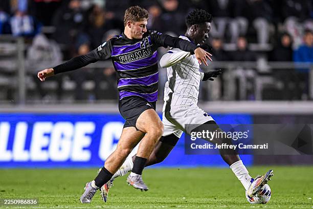 Gianluca Rizzo of the Furman Paladins and Osato Enabulele of the Washington Huskies battle for the ball during the Division I Men's Soccer Semifinals...