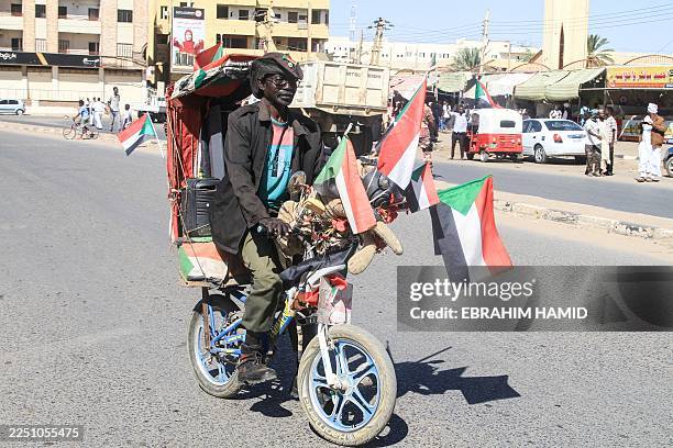 Sudanese man rides his decorated bicycle as others rally in support of the Sudanese armed forces in their battle against the paramilitary Rapid...