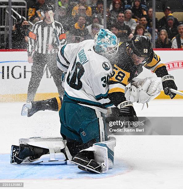 Kris Letang of the Pittsburgh Penguins collides with Yaroslav Askarov of the San Jose Sharks in the first period during the game at PPG PAINTS Arena...