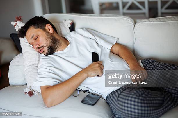 man sleeping with tv turned on - couch potato stock pictures, royalty-free photos & images