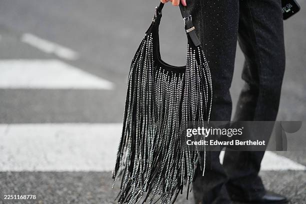Diane Batoukina wears dark grey jeans by Michael Kors, black leather boots pointed shoes by Mango, a black suede sparkling shoulder bag with studded...