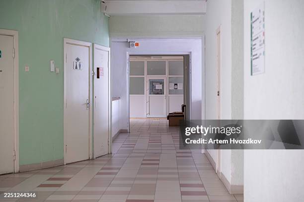 empty old institutional hallway with faded green paint - psychiatrische klinik stock-fotos und bilder