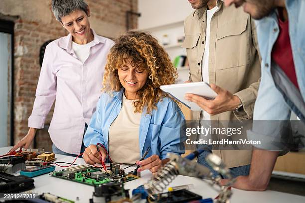 team of engineers learning electronics repair troubleshooting a circuit board - multimeter stock pictures, royalty-free photos & images