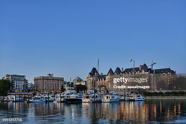 harborfront view of yachts and historic hotel at sunset - victoria canada photos et images de collection