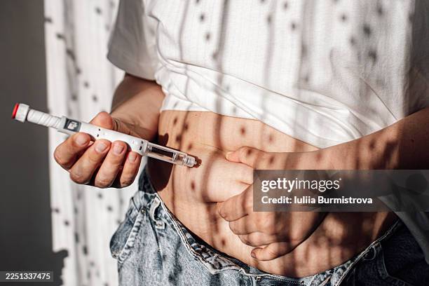 injections for weight loss with semaglutide. an obese woman gives a hormonal injection into the abdomen with a pen syringe. - autoimmune disease stock pictures, royalty-free photos & images