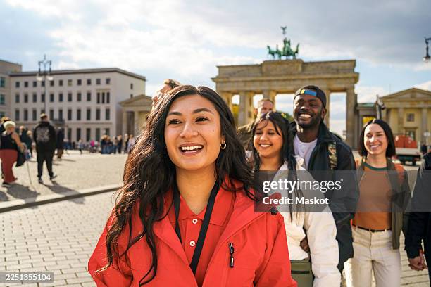 happy female guide guiding tourist while exploring city street against brandenburg gate in berlin - berlin landmark stock pictures, royalty-free photos & images