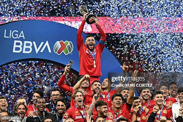 Toluca's forward Alexis Vega lifts the trophy next to teammates after winning the Liga MX Apertura final second leg football match between Toluca and...