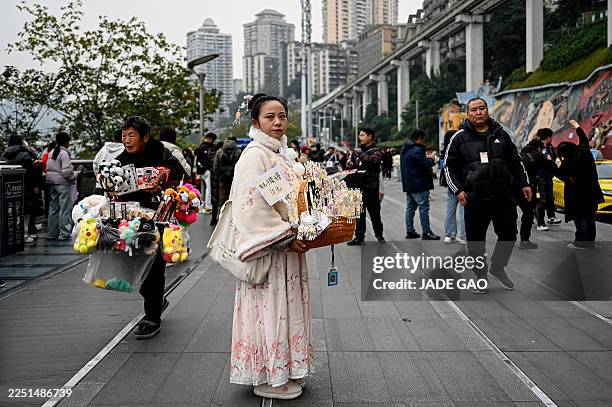 Vendor selling hair accessories waits for customers at the Liziba sightseeing platform in southwestern China's Chongqing municipality on December 15,...