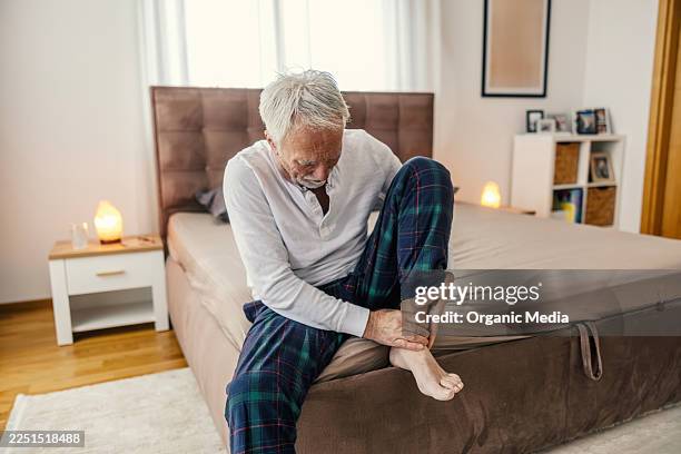 senior man experiencing ankle pain in bedroom - gout stock pictures, royalty-free photos & images