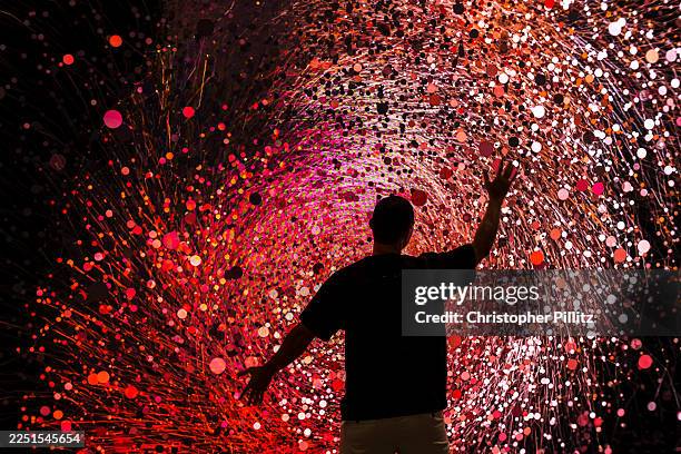 People interact with a large scale digital installation called No Me Olvides by Ix Shells at ART BASEL Miami Art fair which attracts an eclectic and...