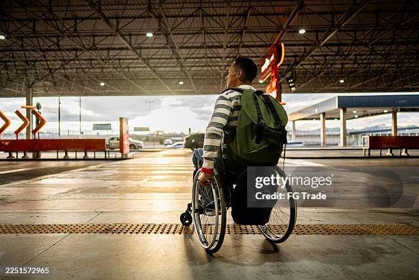 mature wheelchair man leaving airport - paraplegic stock pictures, royalty-free photos & images