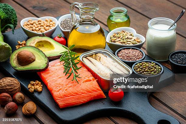 group of healthy ingredients high in unsaturated fatty acid and omega-3. food that improve cholesterol levels, lower blood pressure and reduce inflammation. olive oil, avocado, salmon, sardine, chia seed, nuts - keto meal stock pictures, royalty-free photos & images