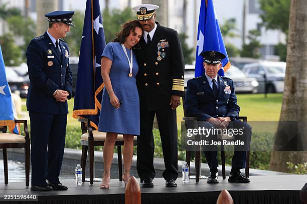 Navy Adm. Alvin Holsey hugs his wife, Dr. Stephanie Holsey, as Chairman of the Joint Chiefs of Staff Gen. Dan Caine and Air Force Lt. Gen. Evan L....