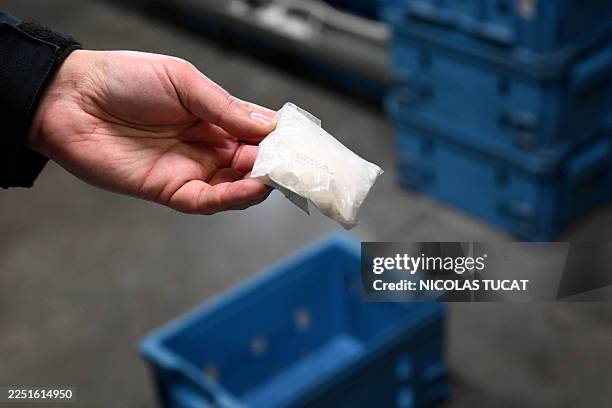 Customs officer displays a cocaine bag seized at Brussels Airport , during a press conference intended to present an overview of drug seizures in...