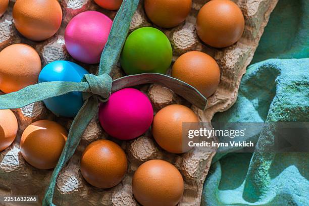 colorful easter eggs with ribbon among brown eggs. - easter breakfast stock pictures, royalty-free photos & images