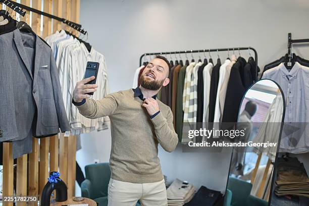 man takes selfie in fashion store while trying on clothes and shopping - fitting room selfie stock pictures, royalty-free photos & images