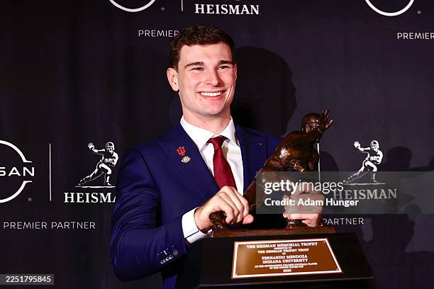 Heisman Trophy winner quarterback Fernando Mendoza of the Indiana Hoosiers poses with The Heisman Memorial Trophy during a news conference at the...