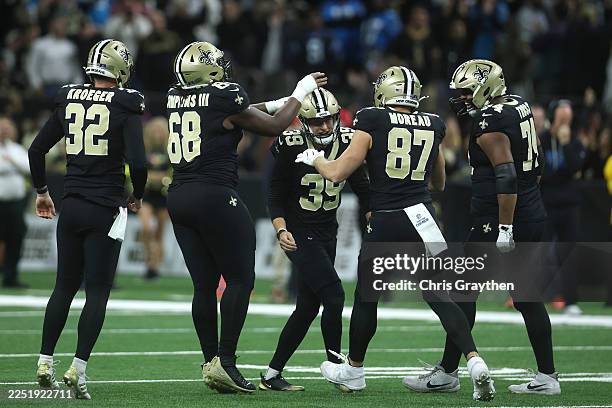 Charlie Smyth of the New Orleans Saints celebrates with teammates after kicking the game winning field goal against the Carolina Panthers during the...