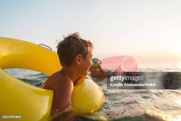kids having fun on summer vacation - rubber ring stock pictures, royalty-free photos & images
