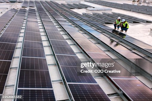 Technicians Inspecting a Solar Panel Installtion Technicians Inspecting a Solar Panel Installtion