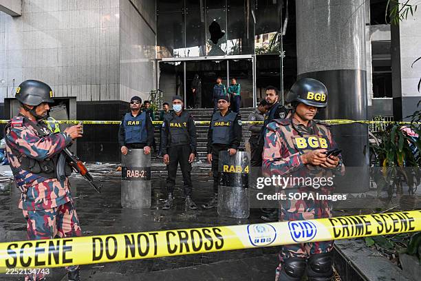 Border Guard Bangladesh and Rapid Action Battalion stand in front of the Daily Star building on Dhaka's Kazi Nazrul Islam Avenue after it was...