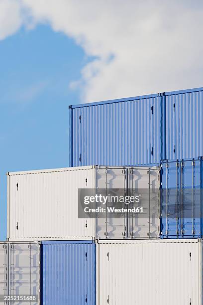 stacked blue and white cargo containers outdoors under blue sky - white empty warehouse stock illustrations