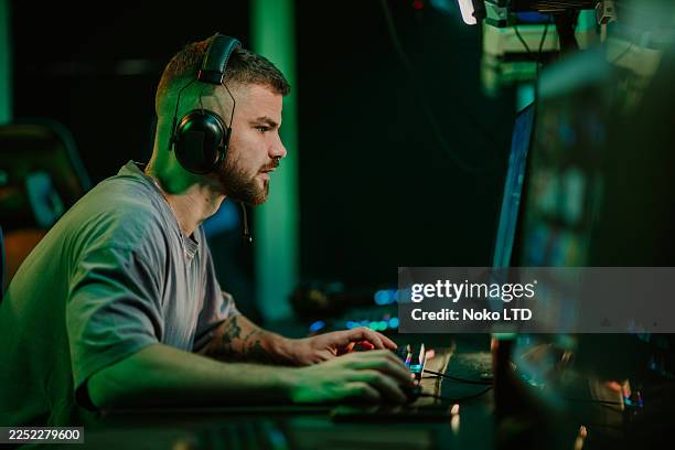 young adult man playing video game on computer - gaming station stock pictures, royalty-free photos & images
