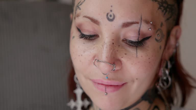 https://media.gettyimages.com/id/2252374321/video/close-up-portrait-of-tattooed-woman-with-piercings.jpg?b=1&s=640x640&k=20&c=Bm5D1xL_w5LHmywyduK6HbvkCTvOW40J4b8rilu0dVU=