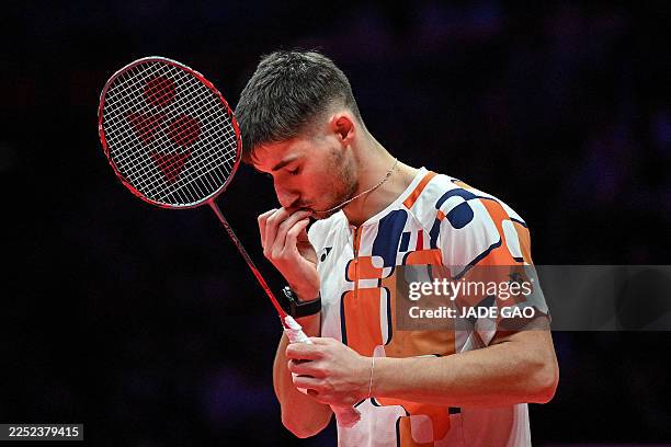 France's Christo Popov kisses his necklace ahead of his men's singles final match against China's Shi Yuqi at the BWF Badminton World Tour Finals in...
