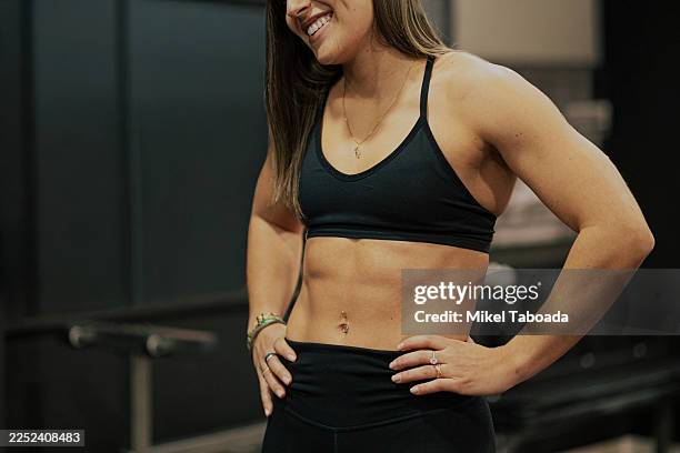 fit woman showing toned abs and core strength - muscolo addominale foto e immagini stock
