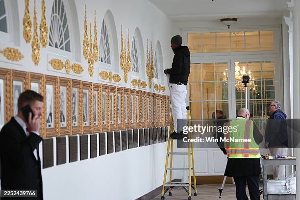 Workers install embellishments above portraits of former U.S. Presidents and newly installed plaques summarizing their legacies as interpreted by the...
