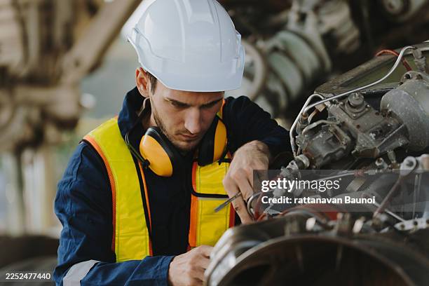los mecánicos inspeccionan los motores de un avión grande antes del despegue en un aeropuerto de verano.(foto) - técnica de imágenes fotografías e imágenes de stock