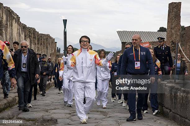 Hong Kong actor and stuntman Jackie Chan holds the torch of the Milan Cortina 2026 Winter Olympicsâ flame inside the Archaelogical site of Pompeii,...