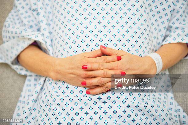 hands on hosptial gown waiting. - examination gown stock pictures, royalty-free photos & images