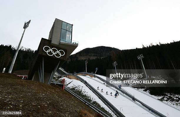 Staff members prepare the slope during a training session at the Ski Jumping arena prior the Open Italian Championship of ski jumping in Predazzo on...