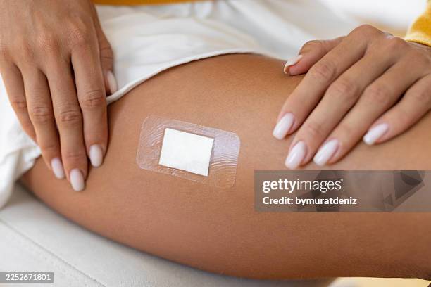 medizinisches pflaster auf frauenhaut-gesundheitskonzept - östrogen stock-fotos und bilder