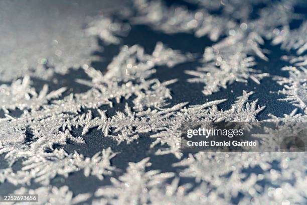 macro photography of ice crystals on frozen surface. - ice crystal stock pictures, royalty-free photos & images
