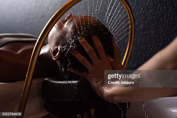 young fwmale is receiving refreshing head wash and relaxing hair spa treatment. - spa bildbanksfoton och bilder