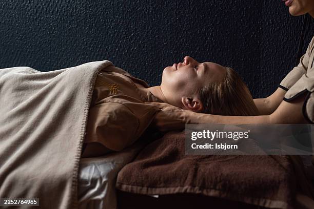 sisw view of female getting relaxing neck massage during spa treatment. - massage table stock pictures, royalty-free photos & images