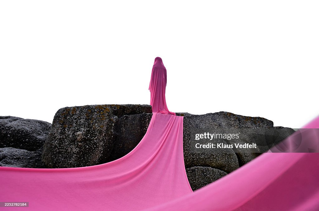 Young non-binary individual wrapped in pink cloth