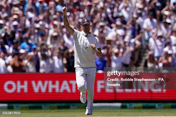England's Ben Stokes celebrates the wicket of Australia's Usman Khawaja in front of an advertising board saying 'oh what a feeling' on day two of the...