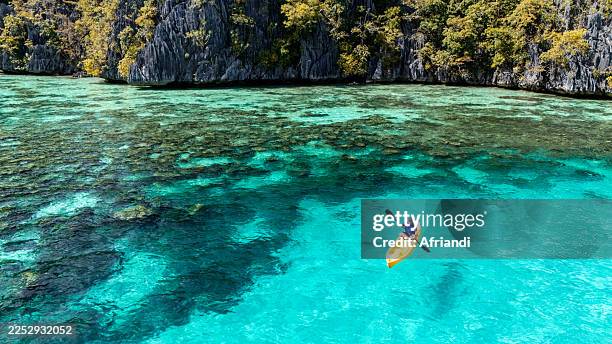 a senior male kayaking in a lagoon, coron island, philippines - lagon photos et images de collection