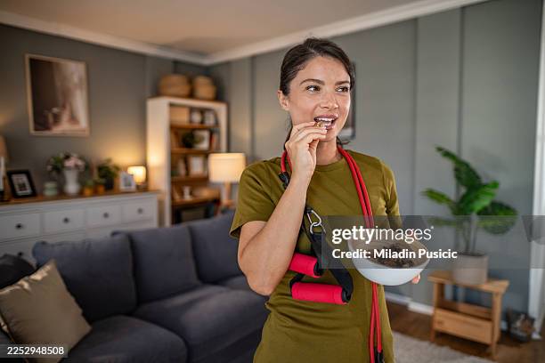 woman eating healthy snack after home workout - trail mix stock pictures, royalty-free photos & images