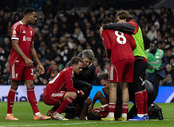 Ryan Gravenberch, Alexis Mac Allister, Dominik Szoboszlai and Federico Chiesa of Liverpool check on team mate Alexander Isak as he is treated by...