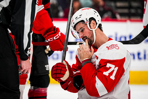 Dylan Larkin of the Detroit Red Wings is slow to get up after being hit in the face in the first period of a game against the Carolina Hurricanes at...