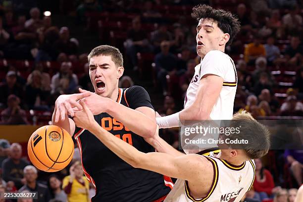 Noah Amenhauser of the Oregon State Beavers battles for a rebound with Noah Meeusen and Santiago Trouet of the Arizona State Sun Devils during the...