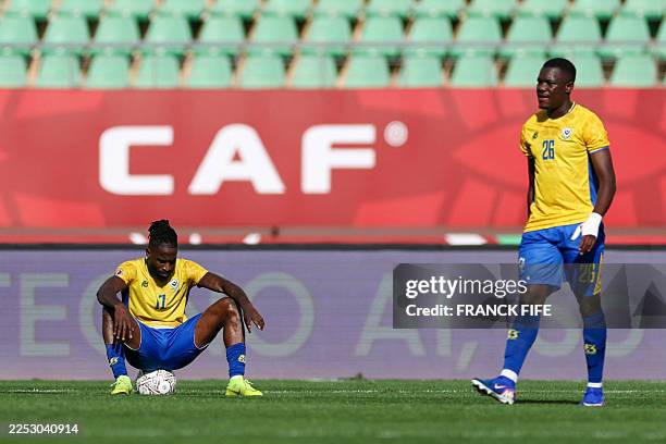 Gabon's midfielder Andre Poko and Gabon's defender Jonathan Do Marcolino react after the Africa Cup of Nations Group F football match between Gabon...