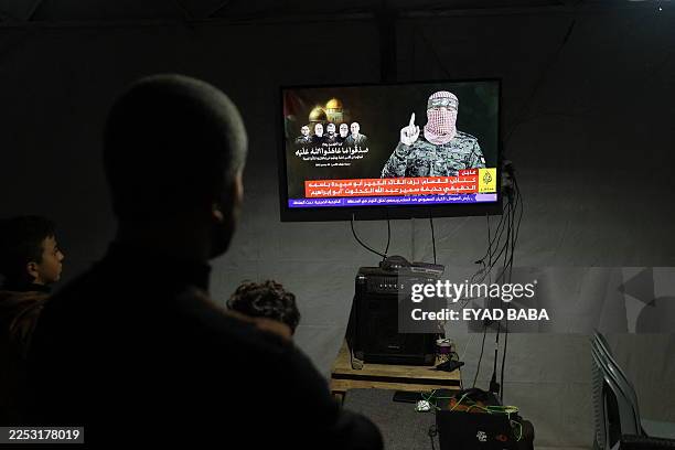 Displaced Palestinians follow the press conference of a new spokesperson for the Ezzedine Al-Qassam Brigades, in Bureij refugee camp Central of Gaza...
